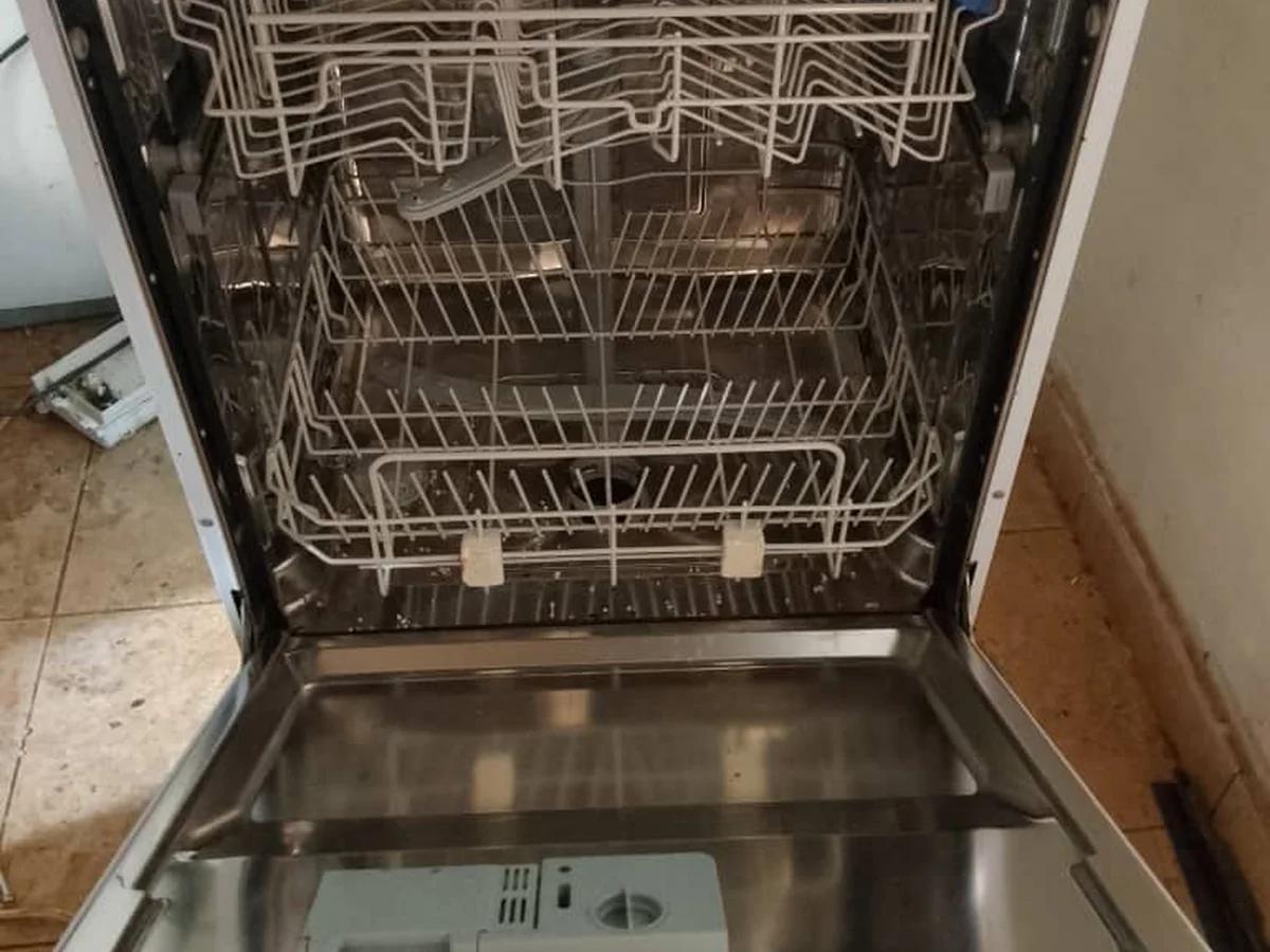 Dishwasher with its door open showing the empty racks
