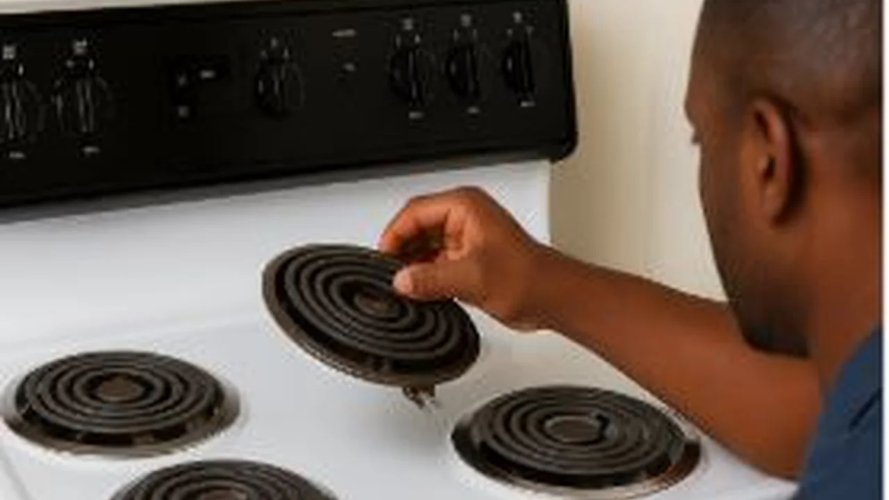 Hand adjusting a coil element on an electric stove